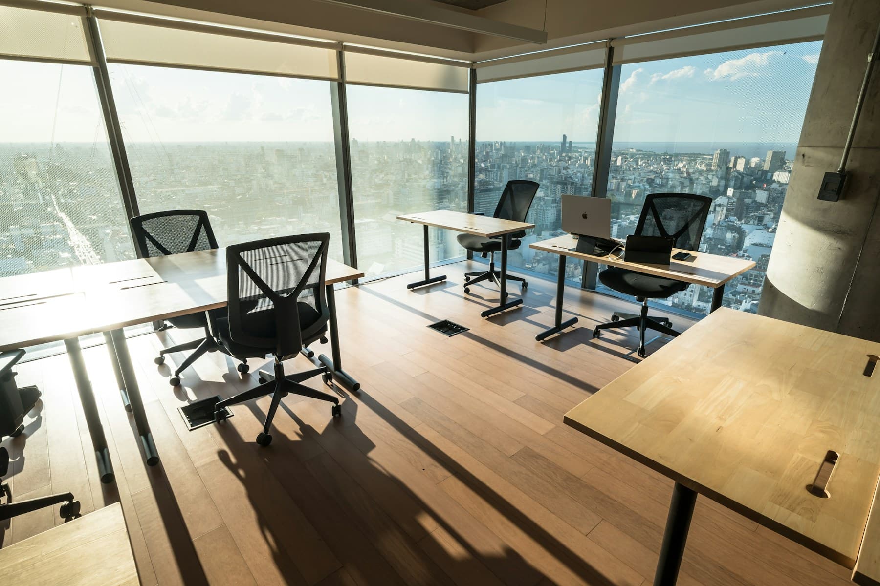 Espace de travail partagé lumineux avec bureaux et vue urbaine
